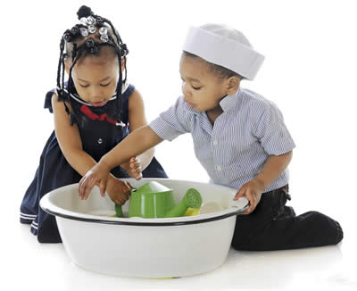 two children playing with toys in a waterbasin